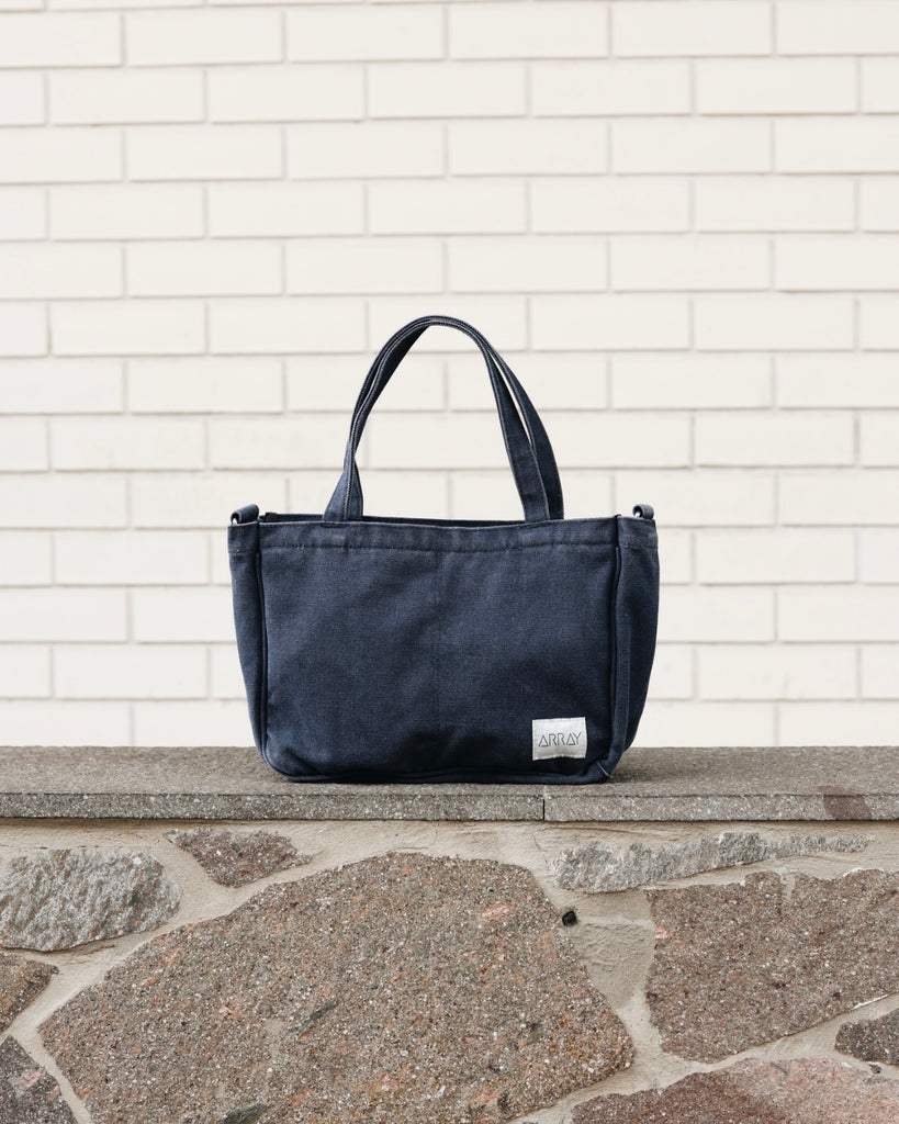 Smaller version of the bestselling everyday zip top pocket tote, with six internal pockets, in a versatile and casual style. The perfect bag for days when you don’t need to carry everything.